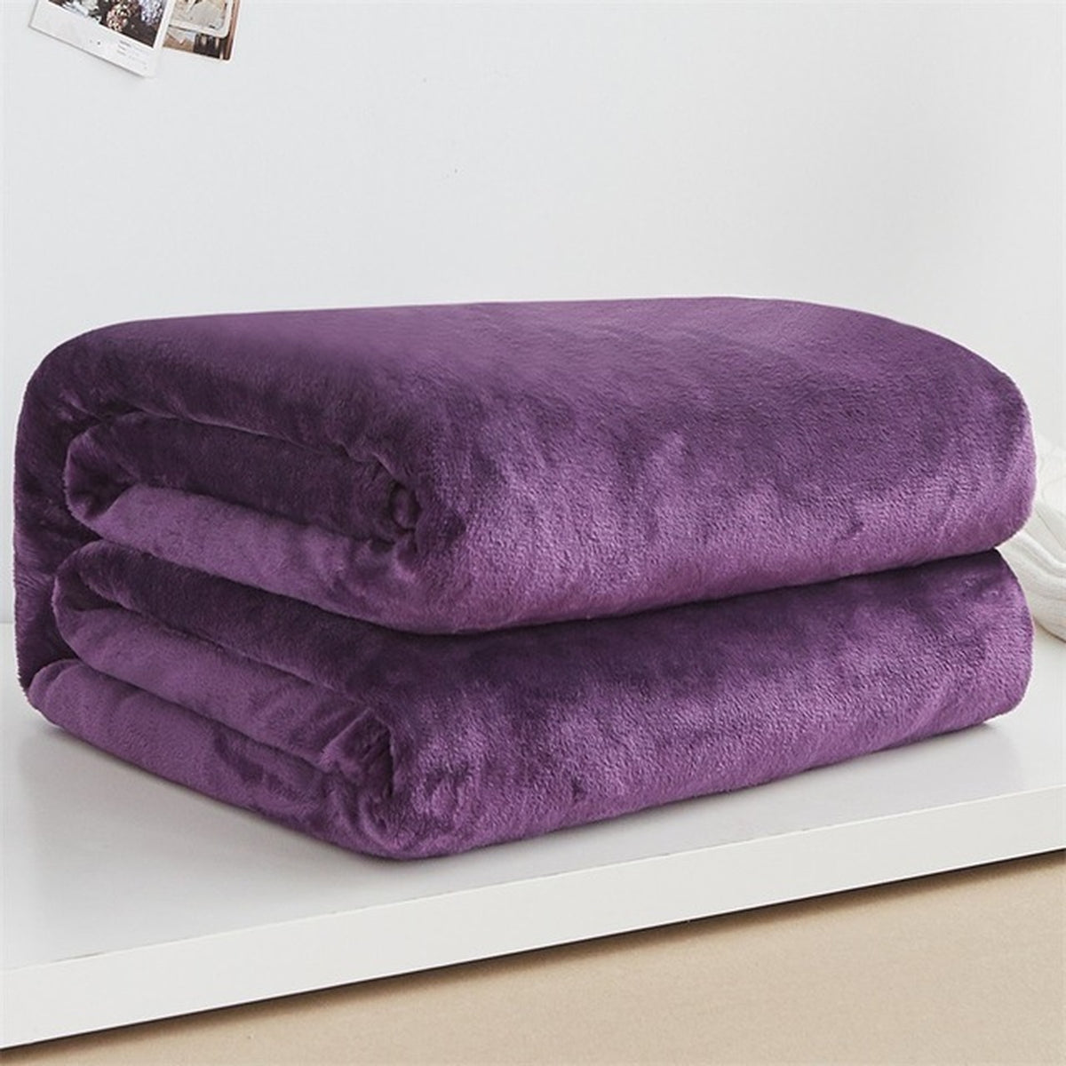 Plaid polaire léger en flanelle coloris violet foncé, plié sur fond clair