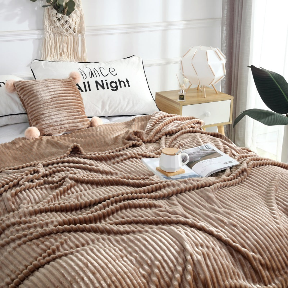 Plaid polaire marron à rayures déplié sur un lit Image