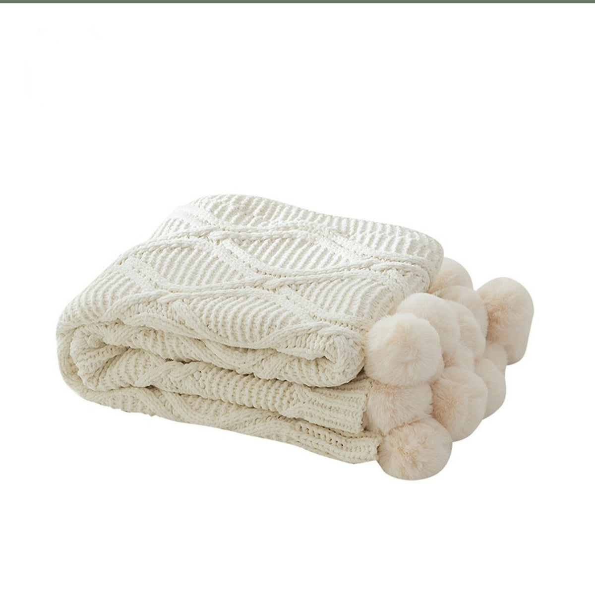 Plaid tricoté beige plié avec ses gros pompons
