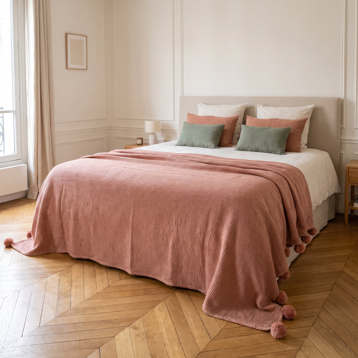 Le plaid rose poudre deplie sur le pied d un lit deux places dans une chambre claire