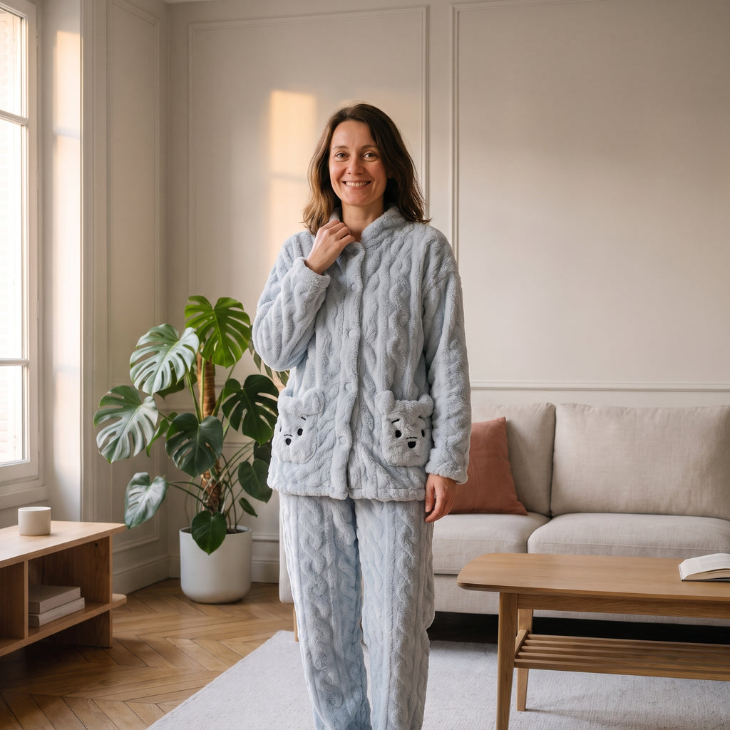 Femme en pyjama en peluche ourson bleu, debout dans un salon