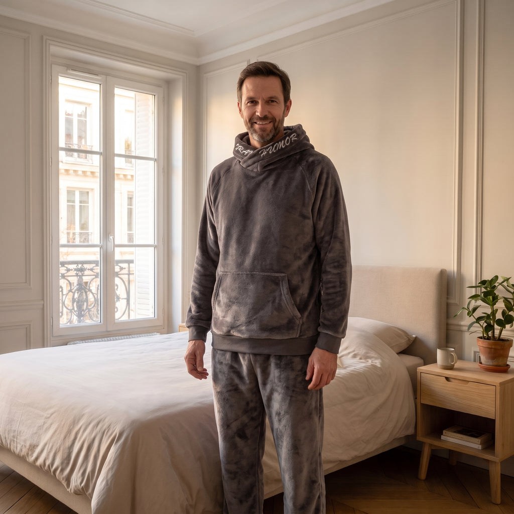 Pyjama homme à capuche gris porté par un modèle dans une chambre
