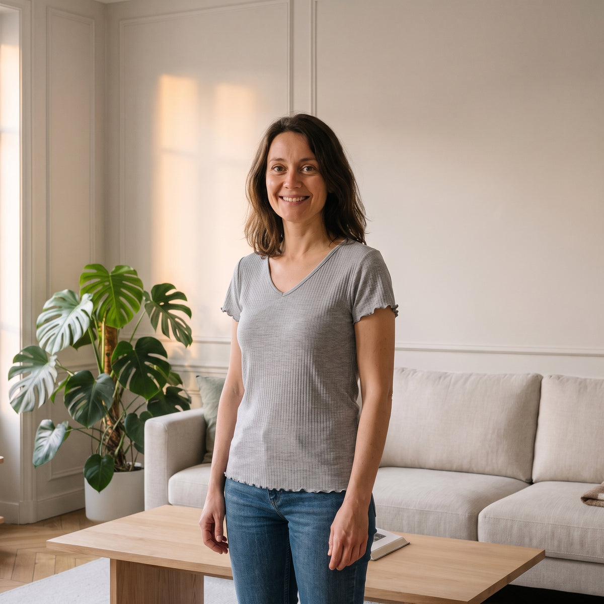Femme portant le t-shirt côtelé col V gris chiné dans un salon