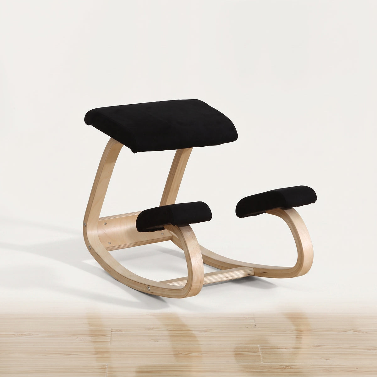 Chaise à genoux ergonomique noire en bois sur fond blanc cassé