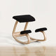 Chaise à genoux ergonomique noire en bois sur fond blanc cassé