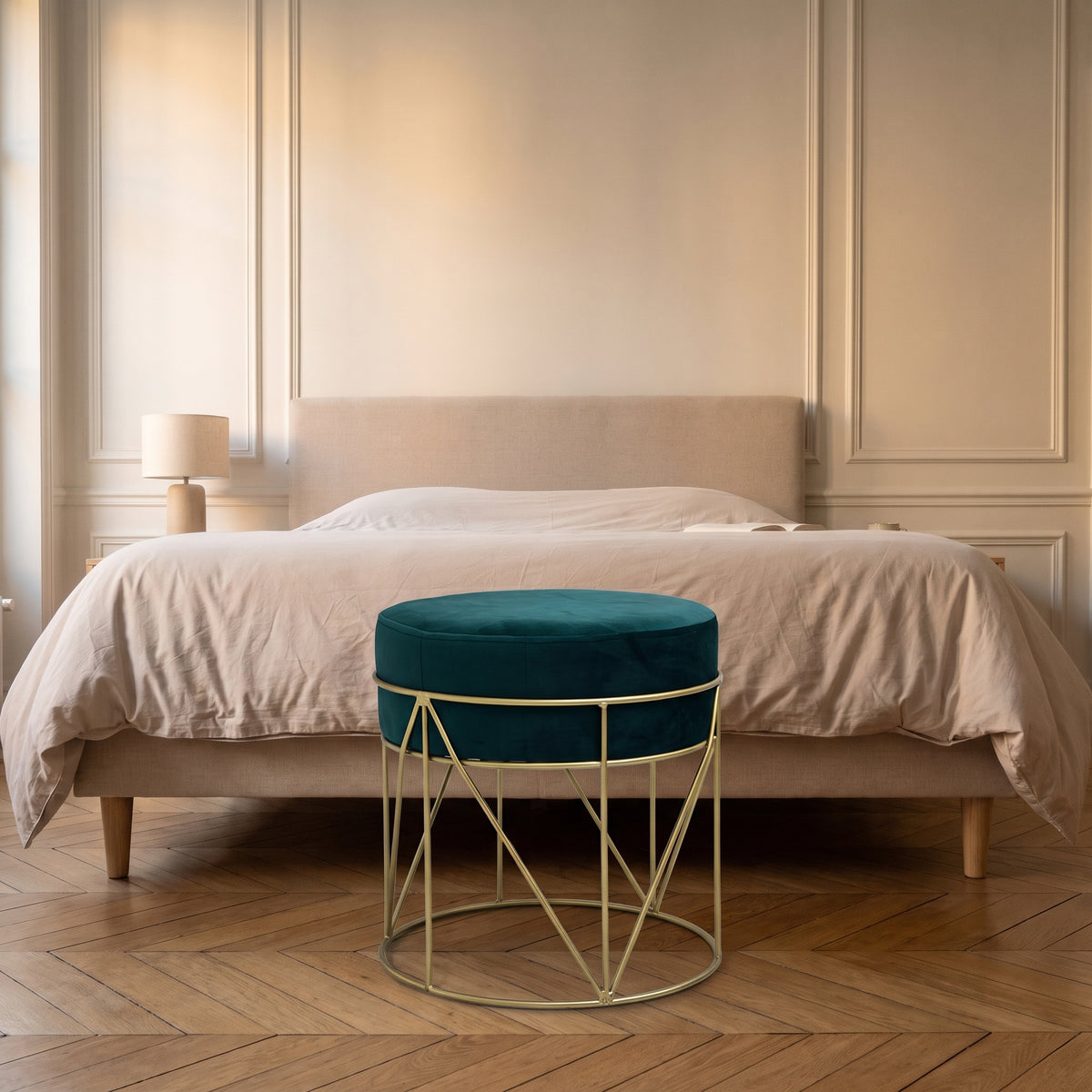 Le pouf en velours vert sapin posé au pied d'un lit Image