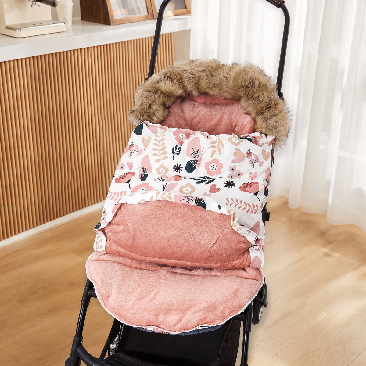 Chancelière chaude installée dans une poussette, ouverte sur sa doublure rose