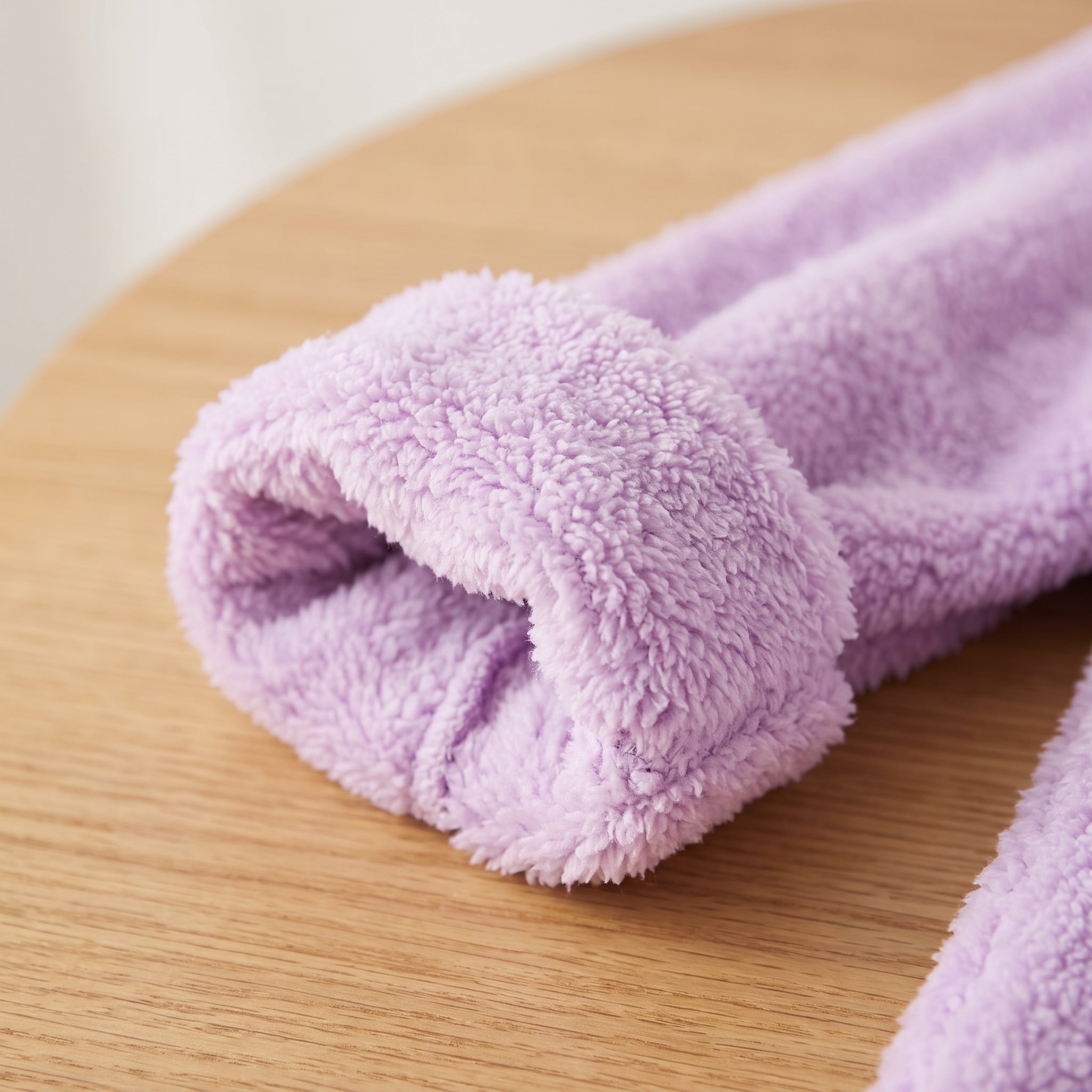 Détail rapproché du poignet retourné et de la surface duveteuse du pull violet Image