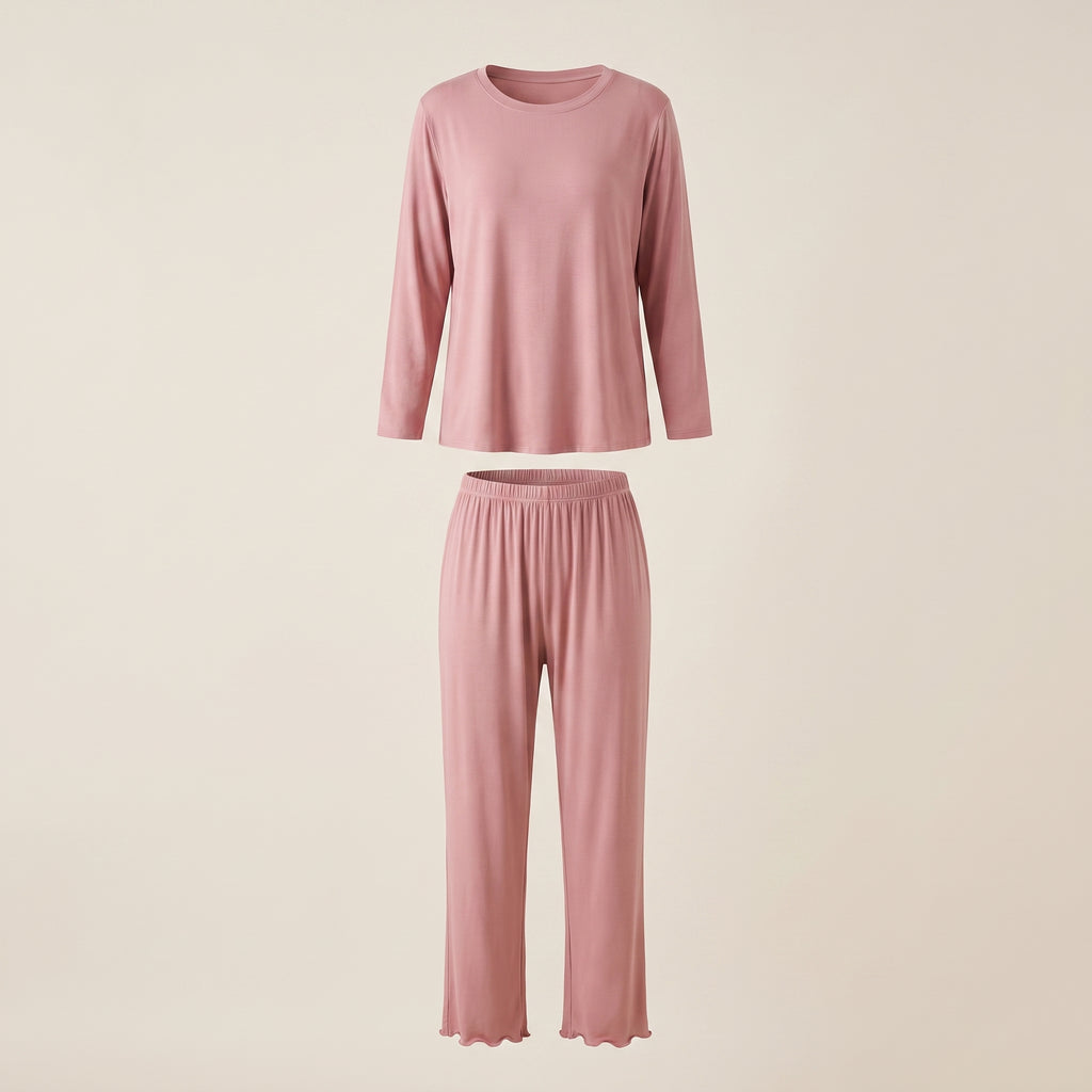 Haut et bas du pyjama en modal rose poudré présentés en volume sur fond beige clair.