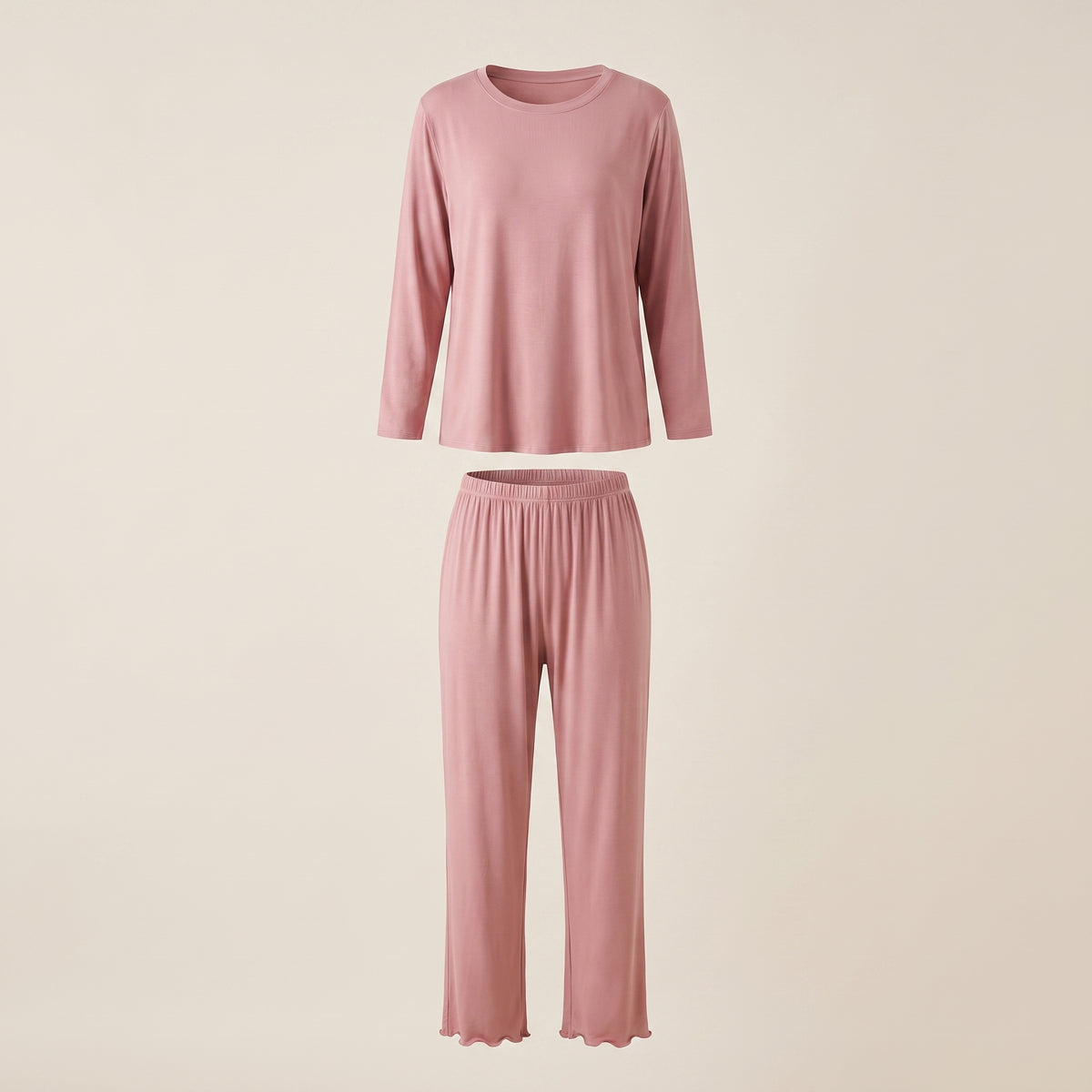 Haut et bas du pyjama en modal rose poudré présentés en volume sur fond beige clair.