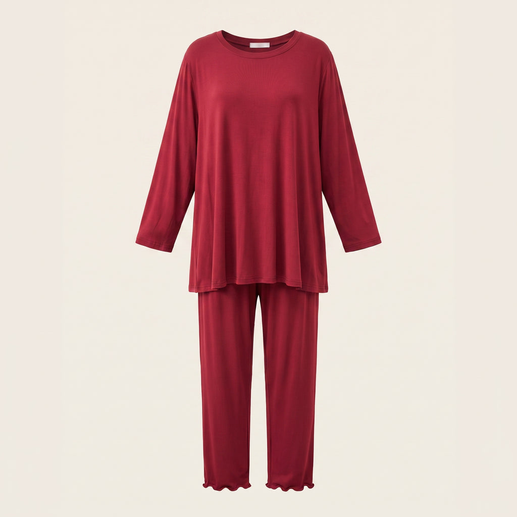 Haut et bas du pyjama en modal rouge présentés en volume sur fond beige clair.