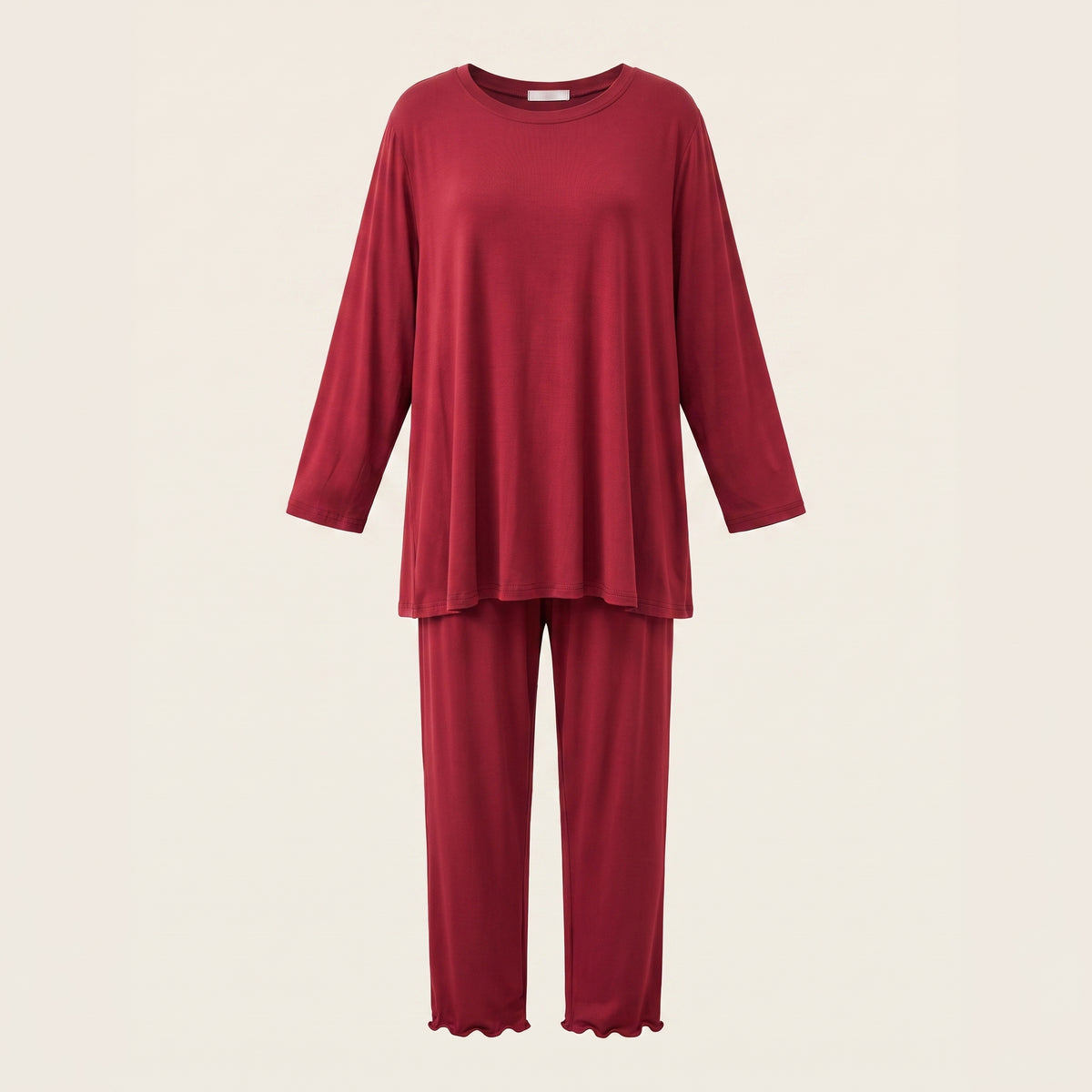 Haut et bas du pyjama en modal rouge présentés en volume sur fond beige clair.