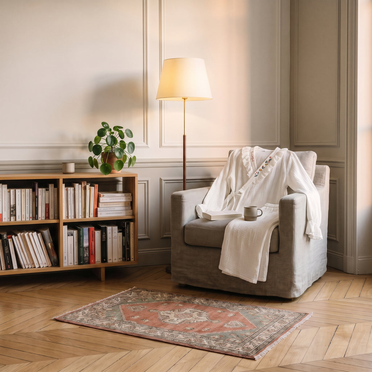 Pyjama en coton blanc écru posé sur un fauteuil de lecture Image
