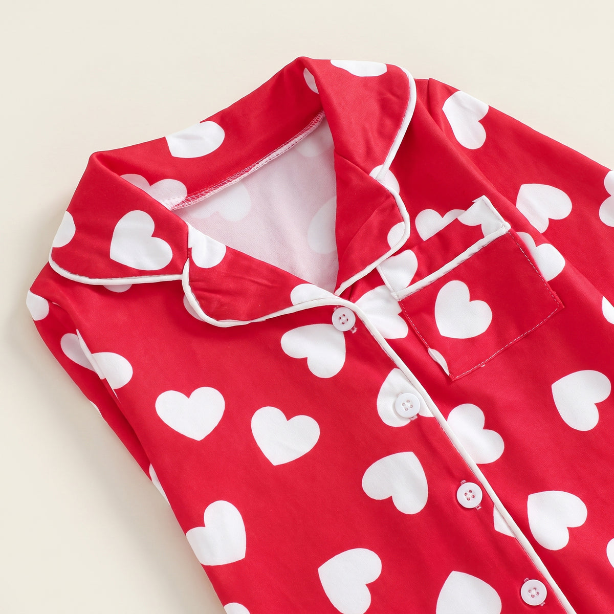 Détail du col, de la poche et des cœurs de la combinaison rouge Image