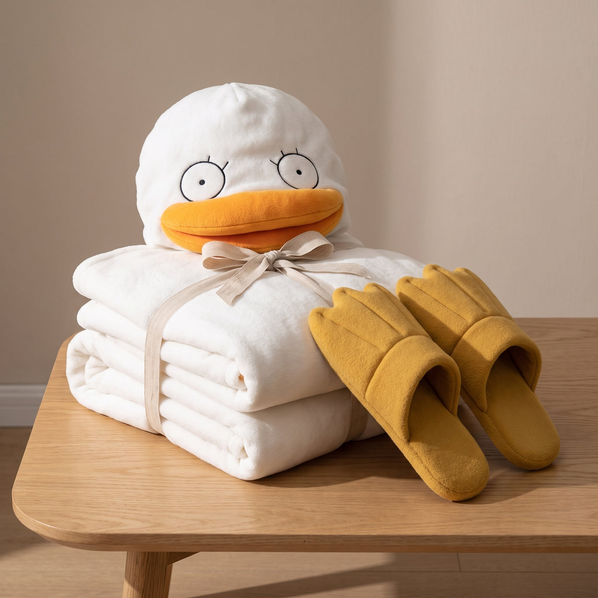 Pyjama canard plié et noué d'un ruban de lin sur une table, capuche à tête de canard sur le dessus et chaussons palmés à côté Image