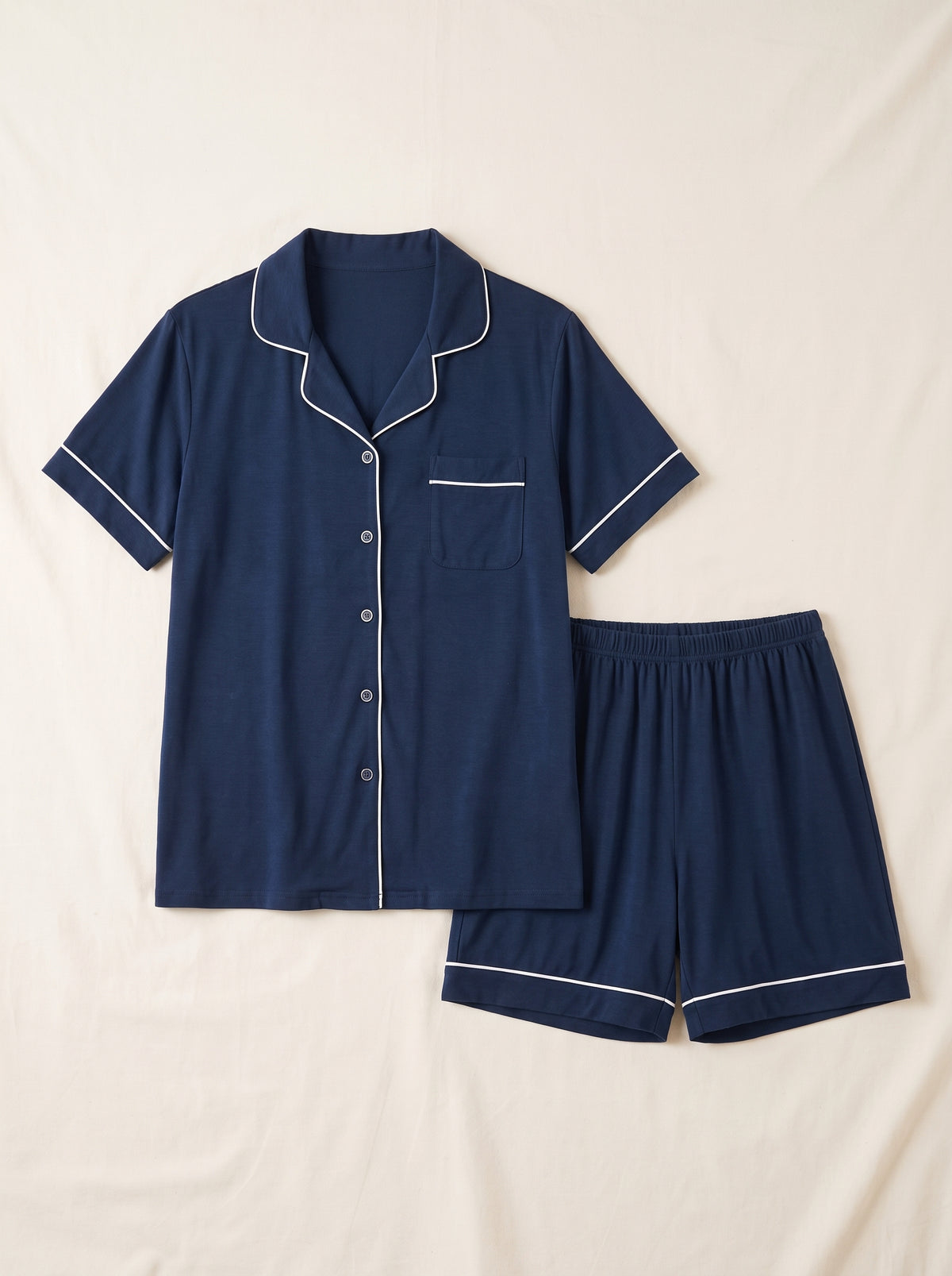 Chemise et short du pyjama d’été bleu marine présentés à plat.