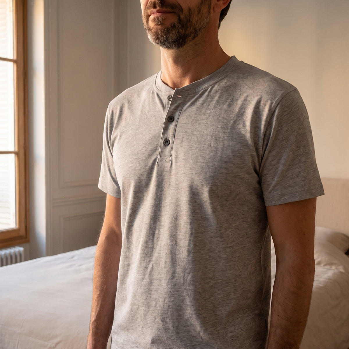 Détail porté du col à trois boutons noirs du pyjama d'été homme gris