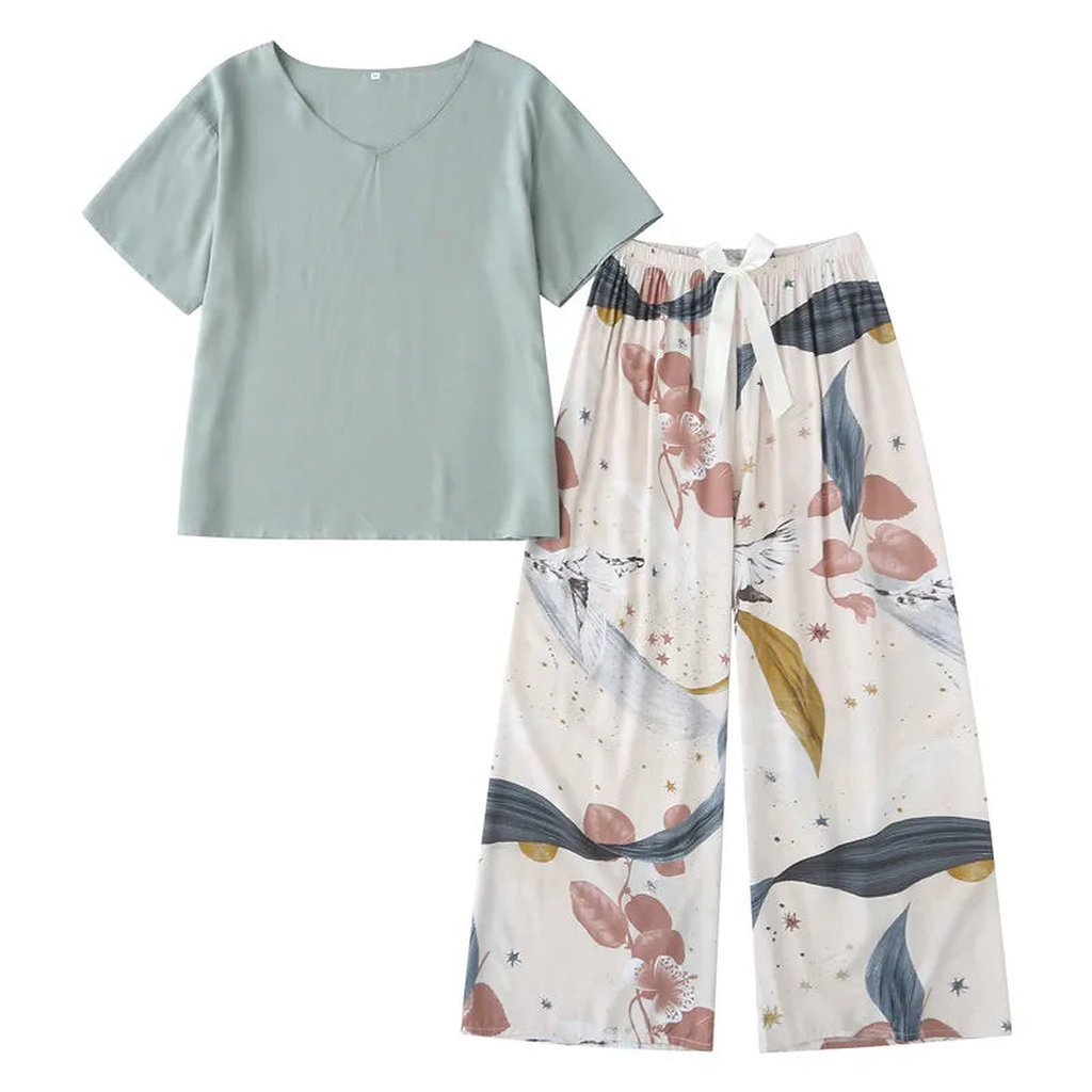 Pyjama deux pièces femme. Haut vert d'eau et pantalon large écru à feuillages, posés à plat sur un cintre.