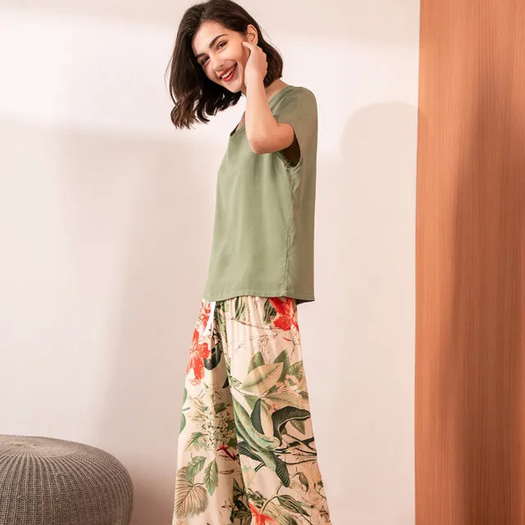 Pyjama femme, haut kaki et pantalon large jardin beige, portés debout devant un mur clair.
