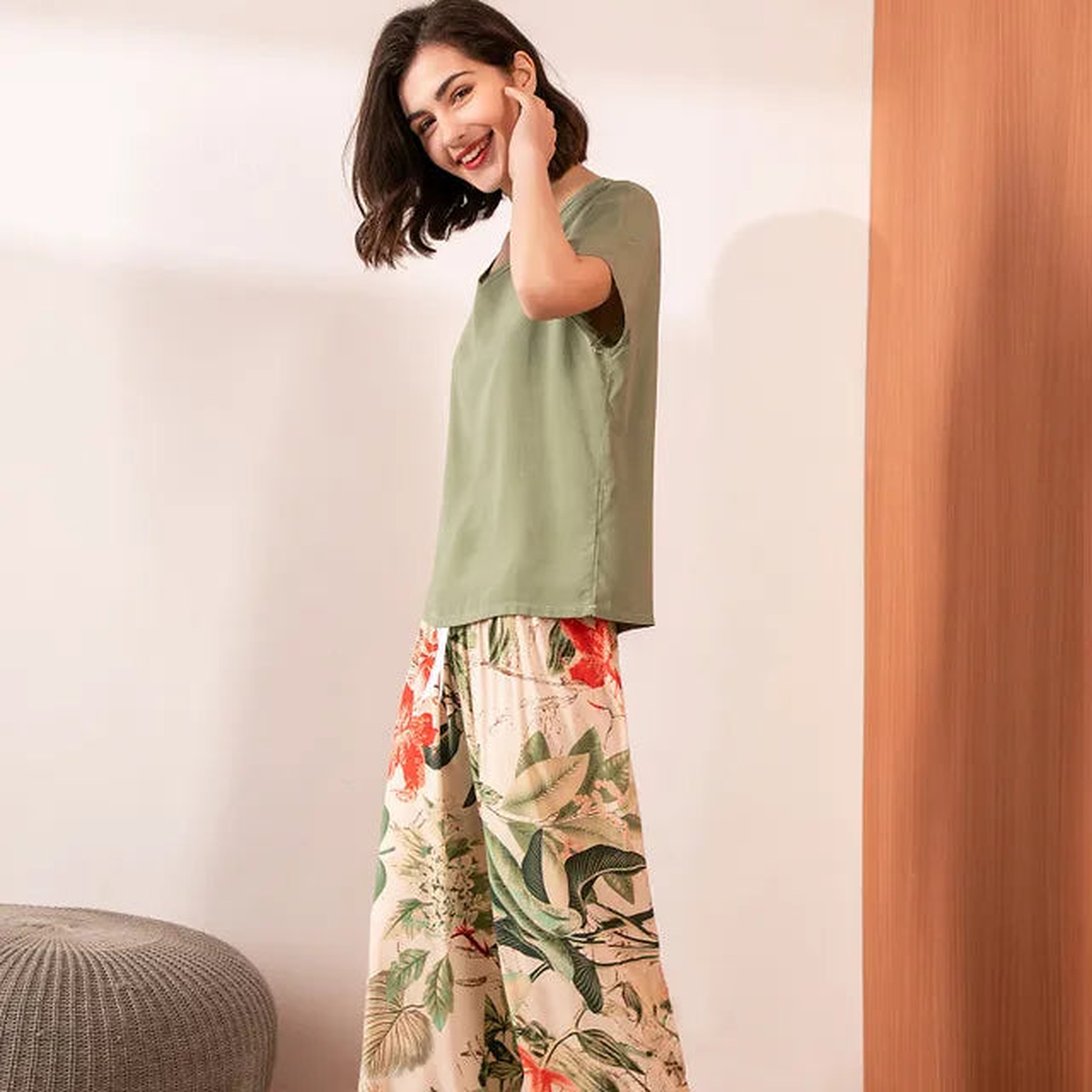 Pyjama femme, haut kaki et pantalon large jardin beige, portés debout devant un mur clair.