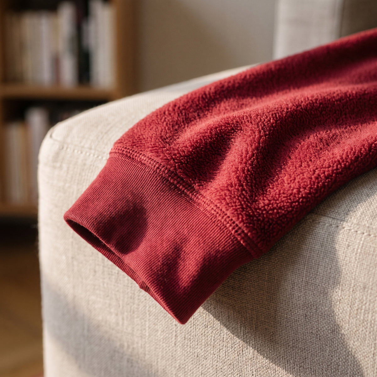 Gros plan du poignet d'un haut de pyjama polaire rouge bordeaux, bordure cousue et surface du molleton Image