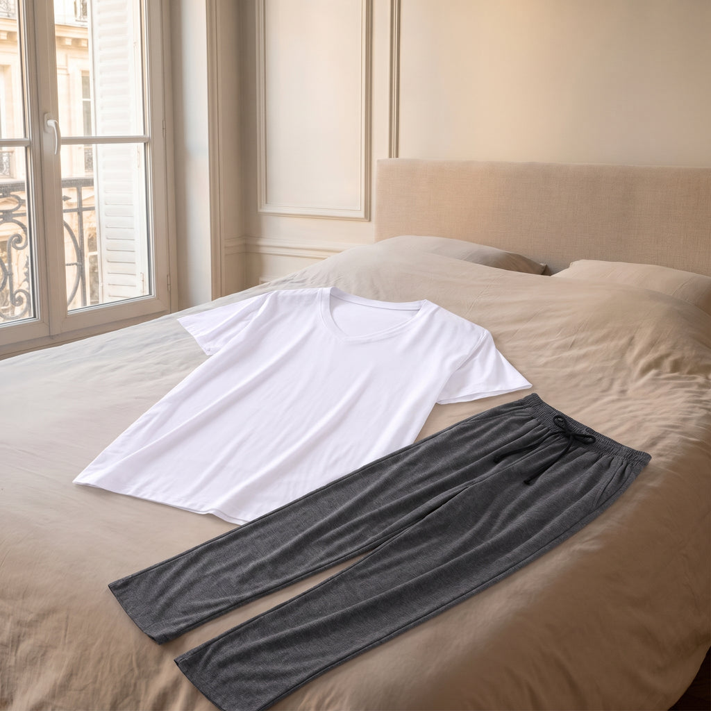 Pyjama homme blanc et gris posé sur le lit de la chambre