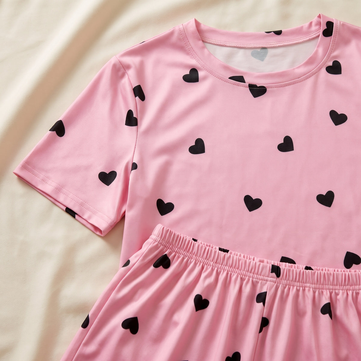 Détail du col rond et de la taille élastiquée du pyjama rose à cœurs noirs