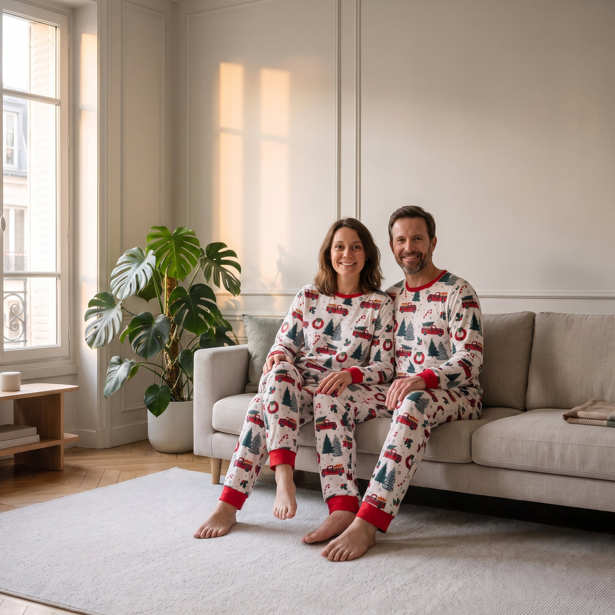 Couple en pyjamas de Noël sapins et voitures dans le salon Image