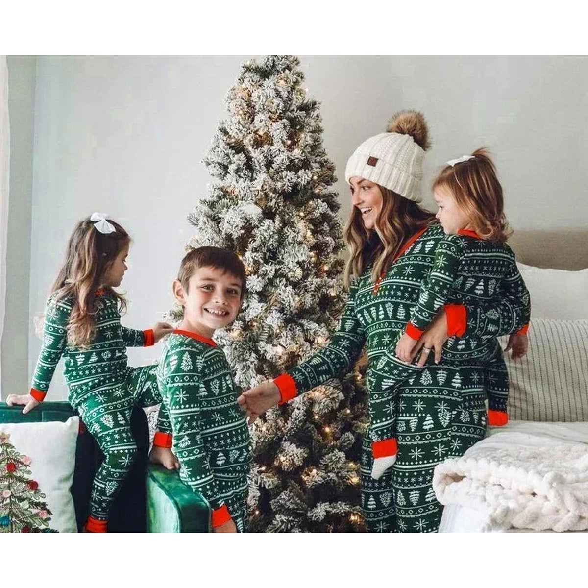 Famille réunie autour du sapin en pyjama vert Image