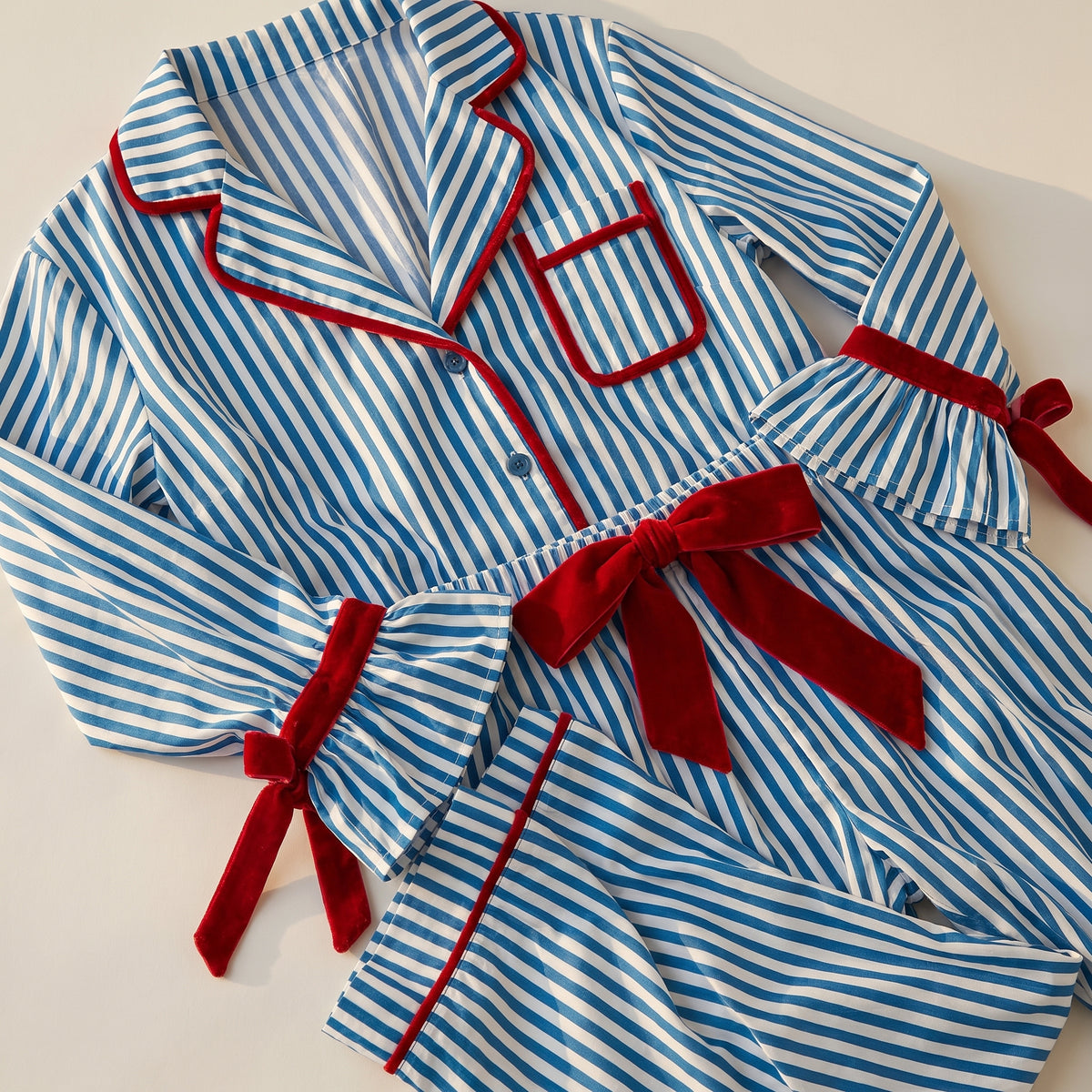 Pyjama de Noël femme bleu rayé présenté à plat sur fond uni