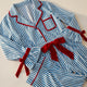 Pyjama de Noël femme bleu rayé présenté à plat sur fond uni