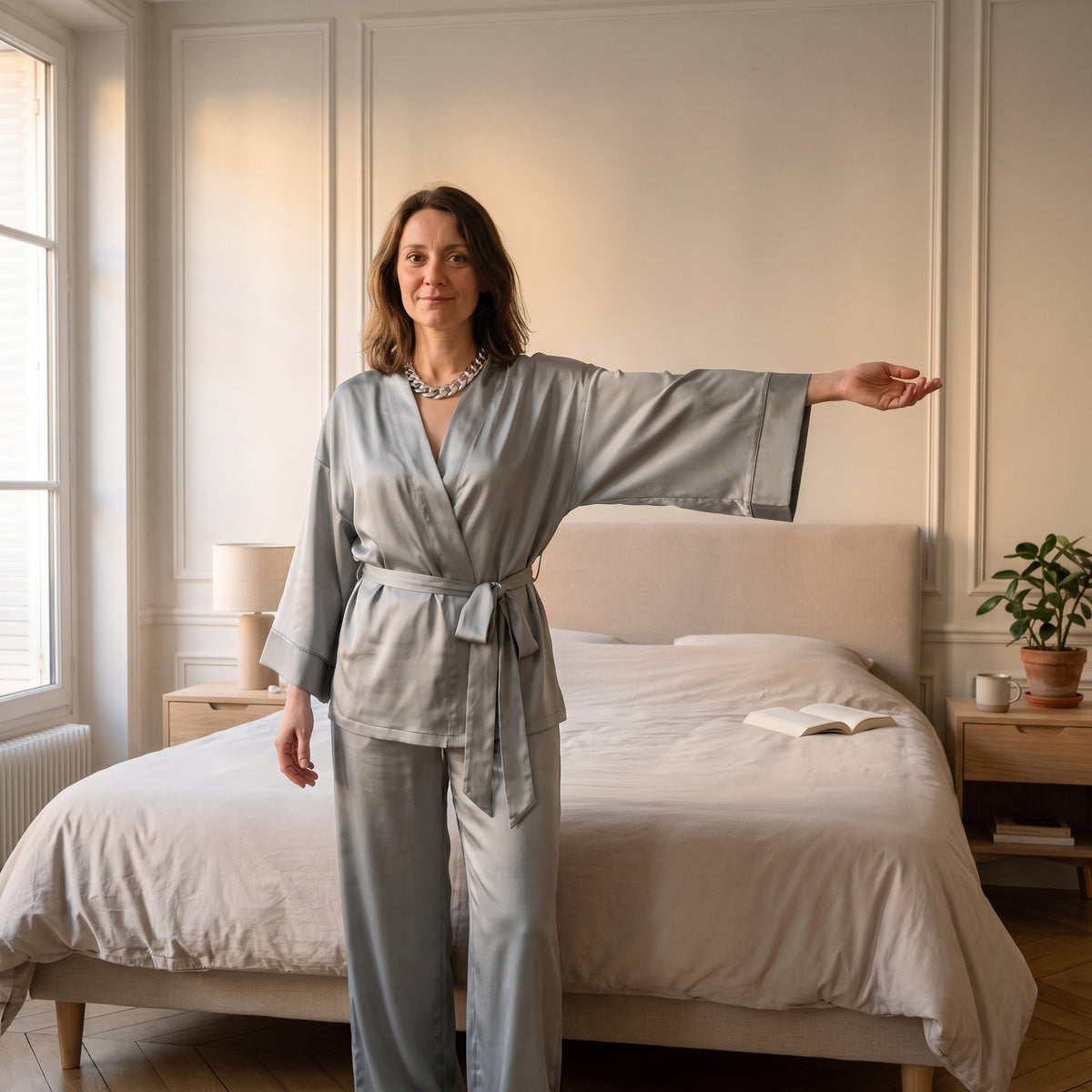 Femme du casting portant le pyjama satin gris à manches trois-quarts évasées dans la chambre