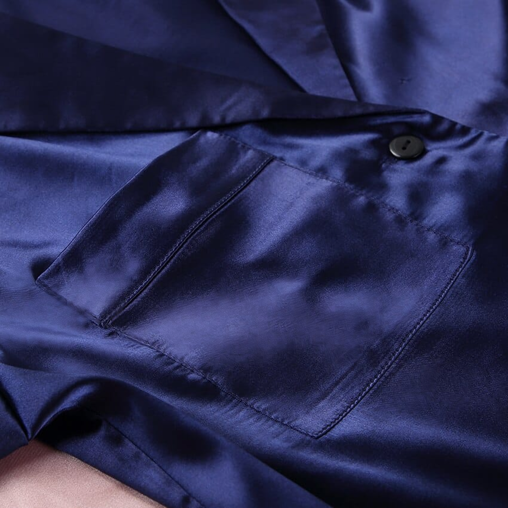 Détail réel de la poche poitrine et du bouton du pyjama satiné bleu