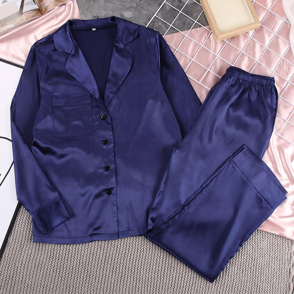 Ensemble pyjama satiné bleu posé à plat, chemise et pantalon
