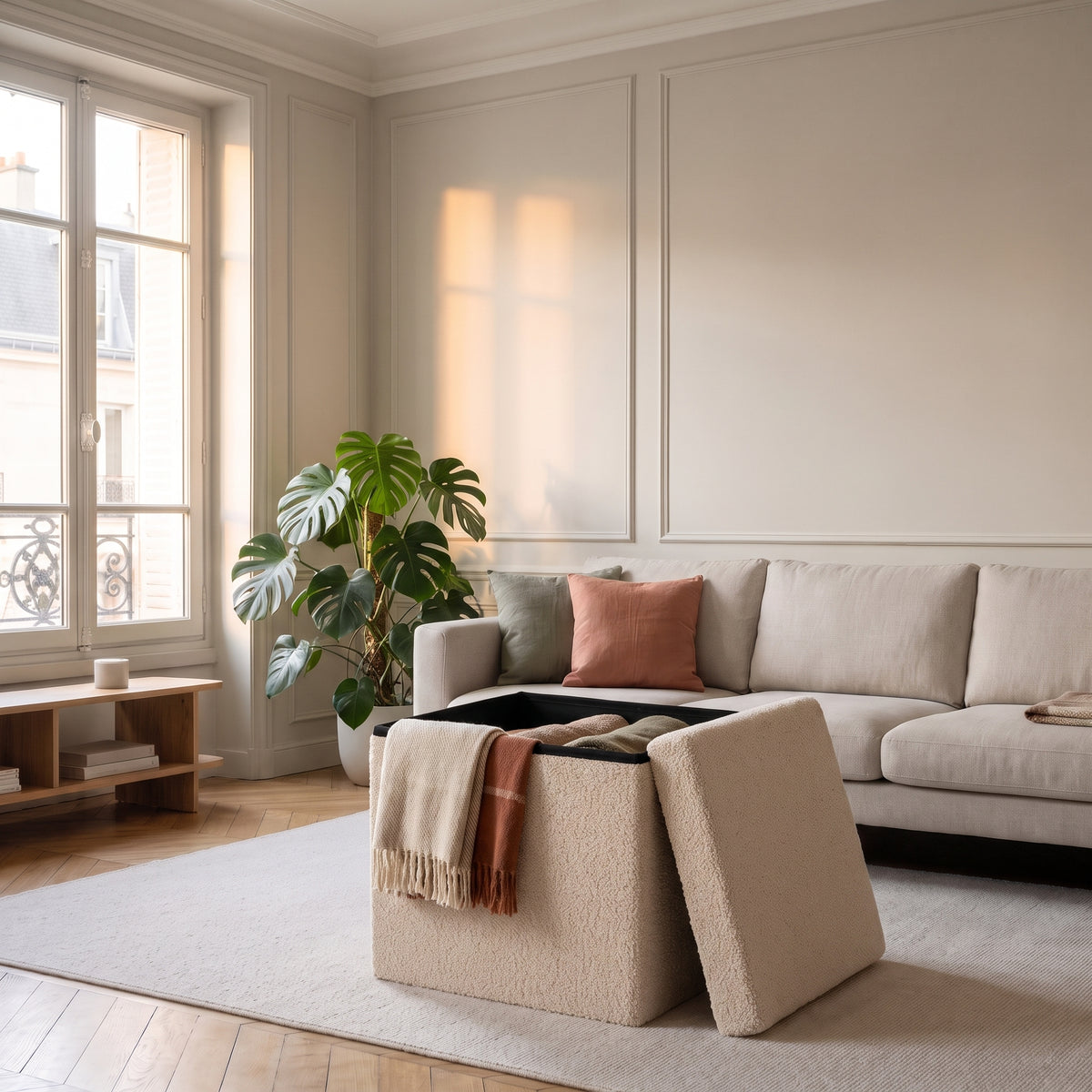 Pouf coffre beige ouvert avec des plaids rangés dans le salon