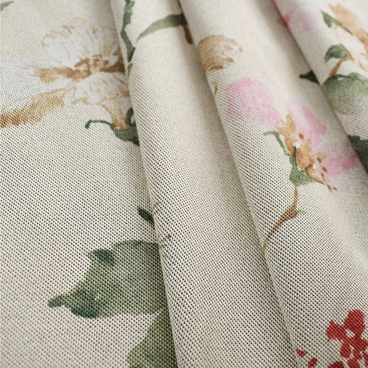 Détail du motif floral rose, rouge, vert et beige du rideau champêtre