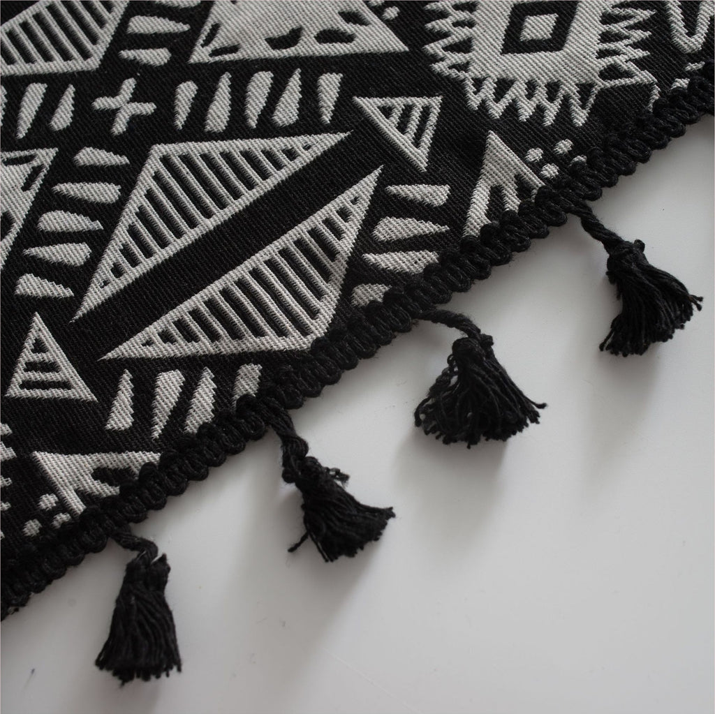 Détail du motif géométrique et des glands noirs du rideau ethnique