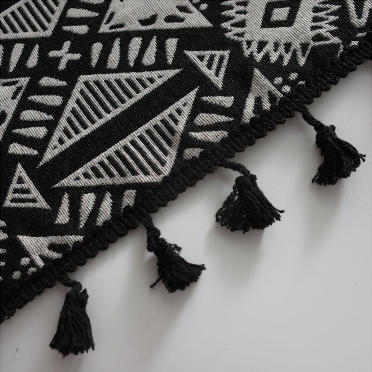Détail du motif géométrique et des glands noirs du rideau ethnique
