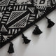 Détail du motif géométrique et des glands noirs du rideau ethnique