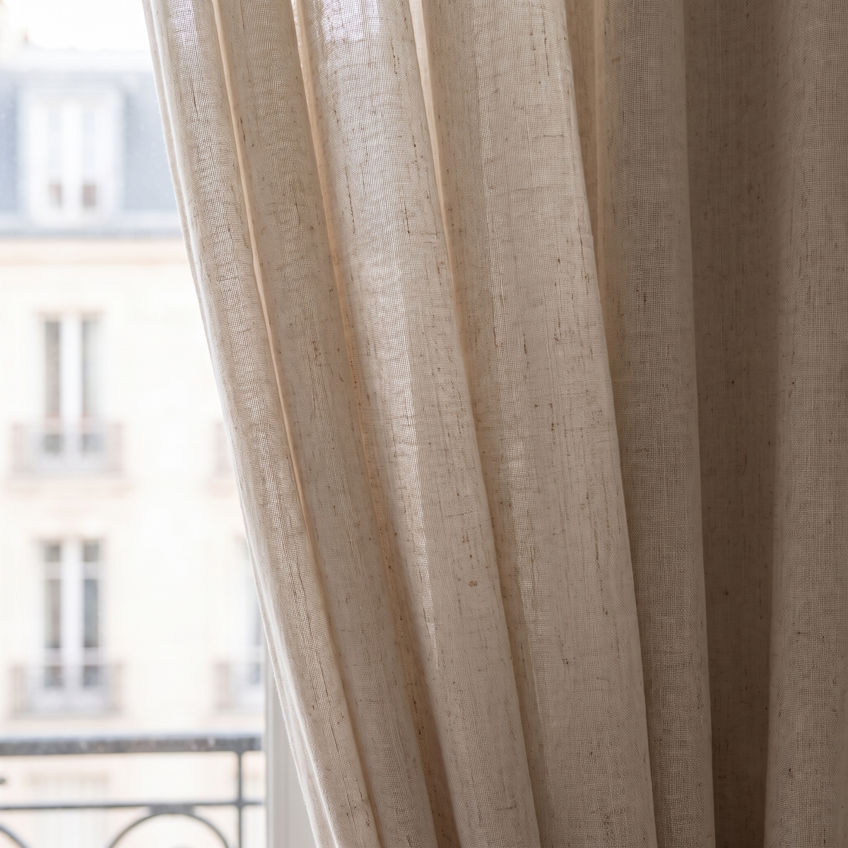 Détail de la trame et de la transparence du rideau voilage en tulle beige