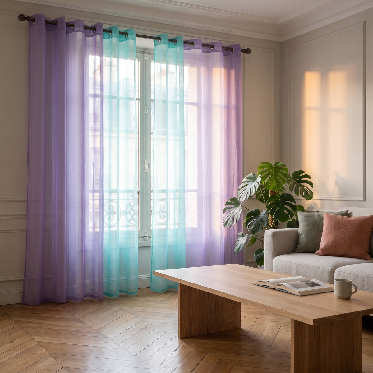 Deux pans du rideau en tulle dégradé violet et vert fermés devant une fenêtre de salon