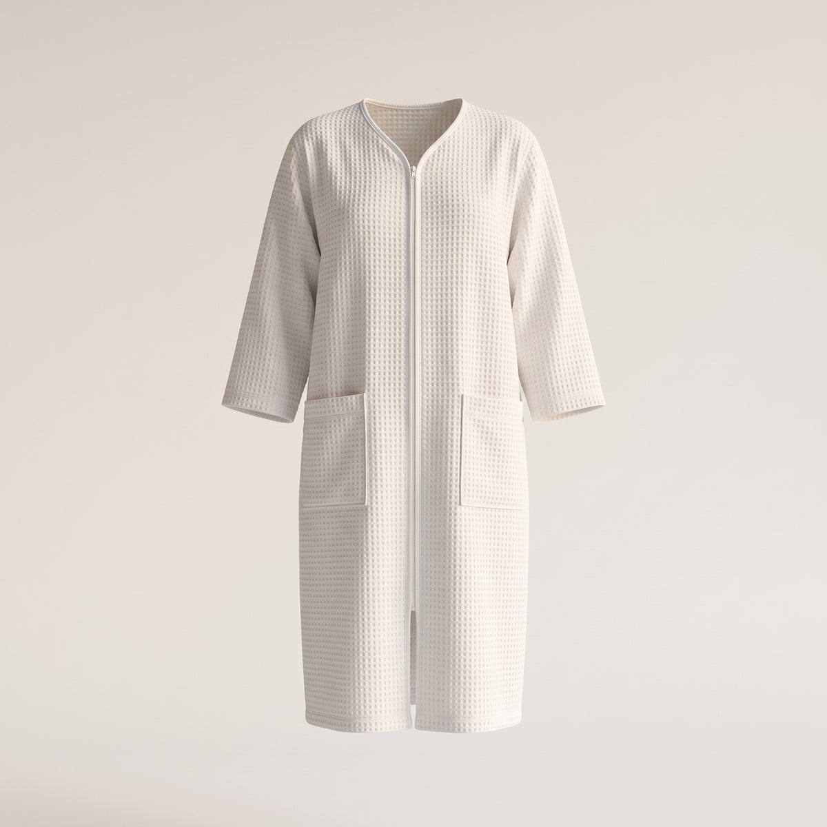 Robe de chambre zippée blanche sur mannequin invisible, fond uni blanc cassé