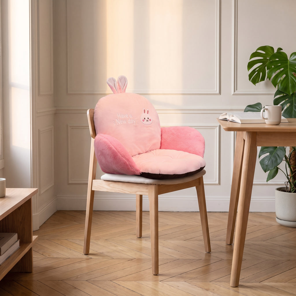 Coussin de chaise rose clair avec oreilles de lapin, installe sur une chaise en bois du coin repas