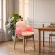 Coussin de chaise rose mixte avec oreilles de lapin, installe sur une chaise en bois du coin repas