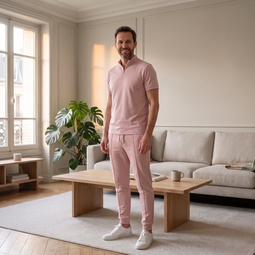 Homme en ensemble polo et pantalon rose poudré dans un salon parisien