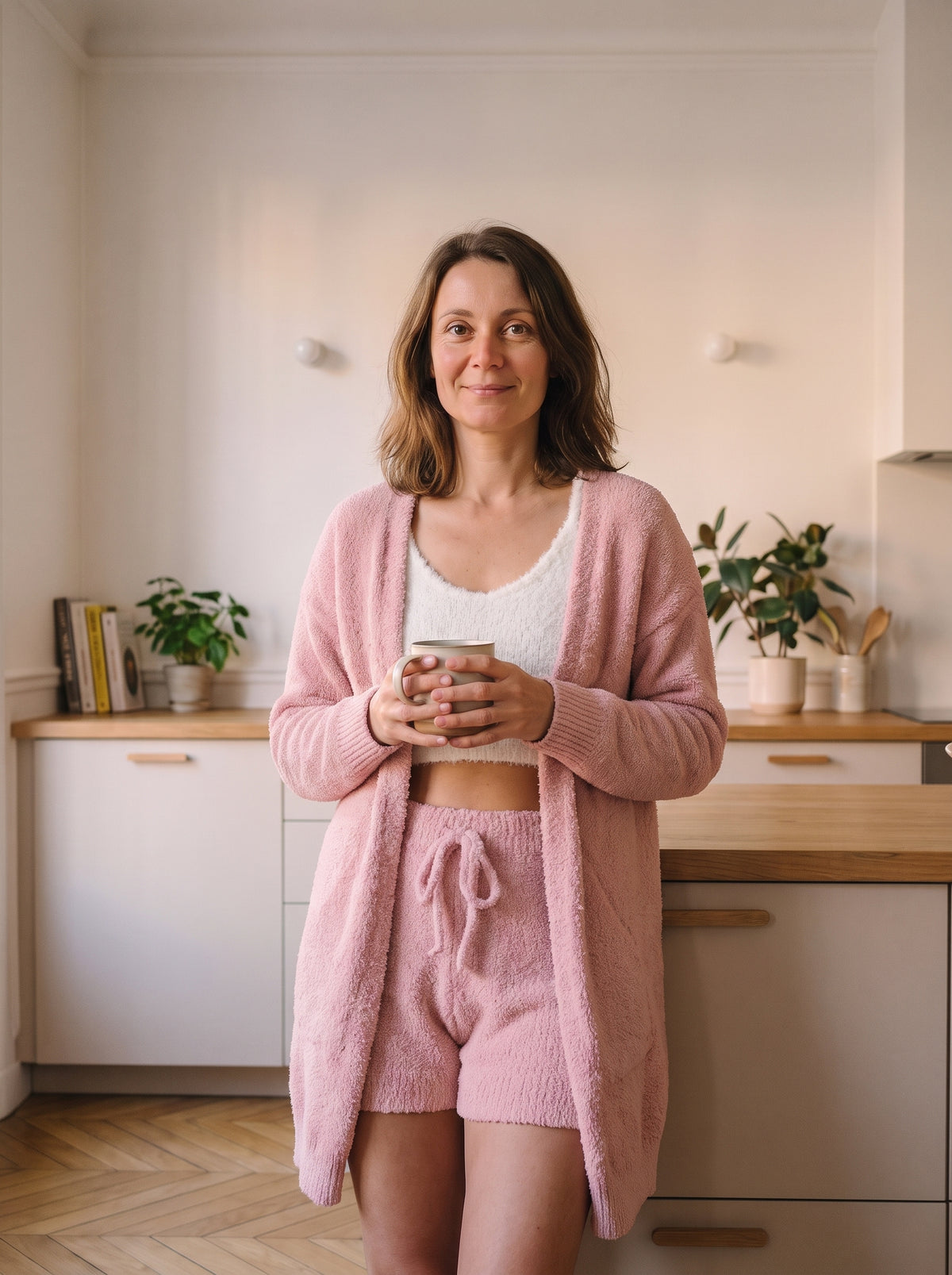 Ensemble pyjama trois pièces en maille peluche rose, porté dans un intérieur