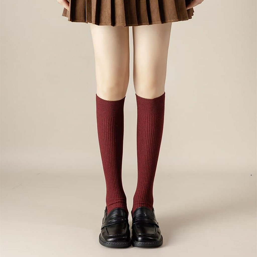 Chaussettes hautes rouge profond portees sous le genou avec des mocassins