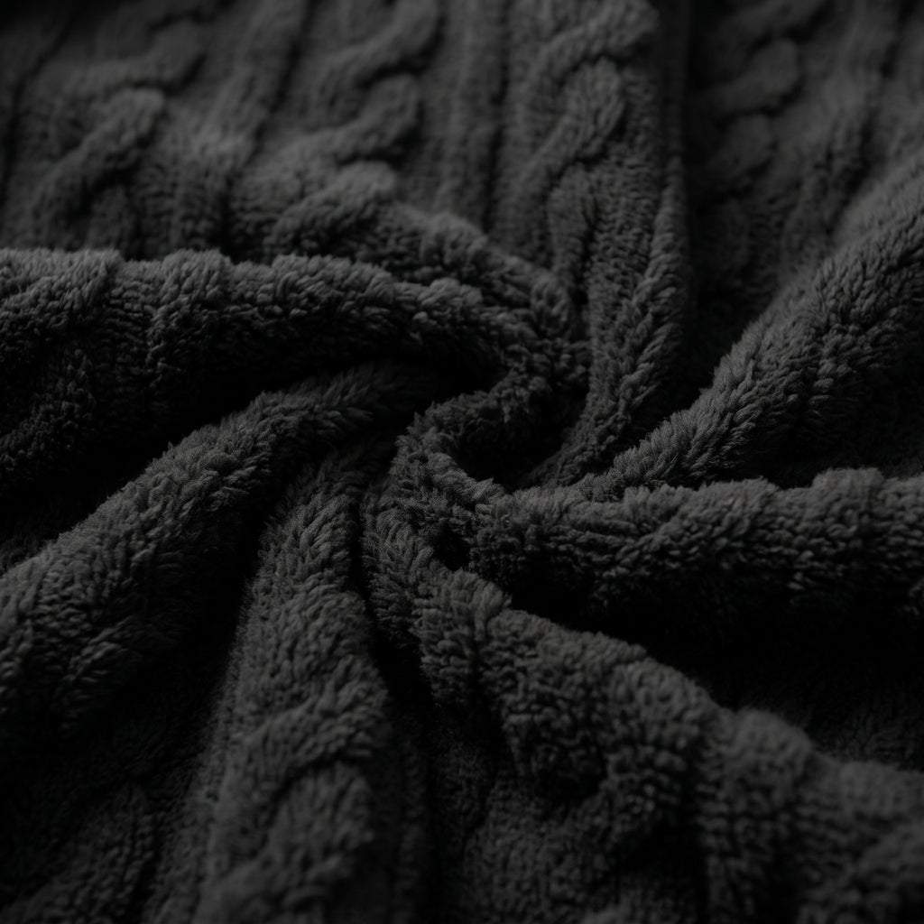 Plan macro du relief torsadé de la peluche noire de l’ensemble cocooning