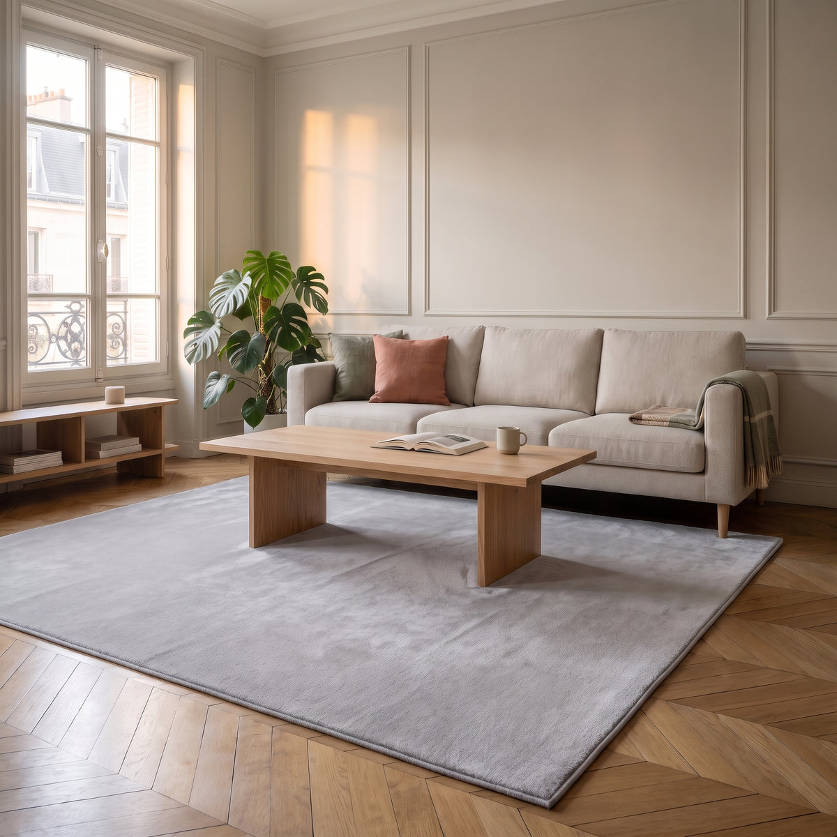 Tapis en fausse fourrure gris clair déroulé devant un canapé clair dans un salon