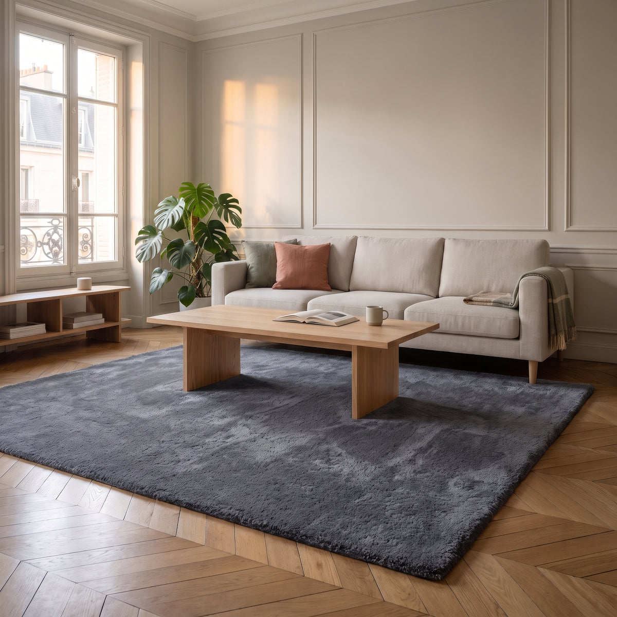 Tapis en fausse fourrure gris foncé déroulé devant un canapé clair dans un salon